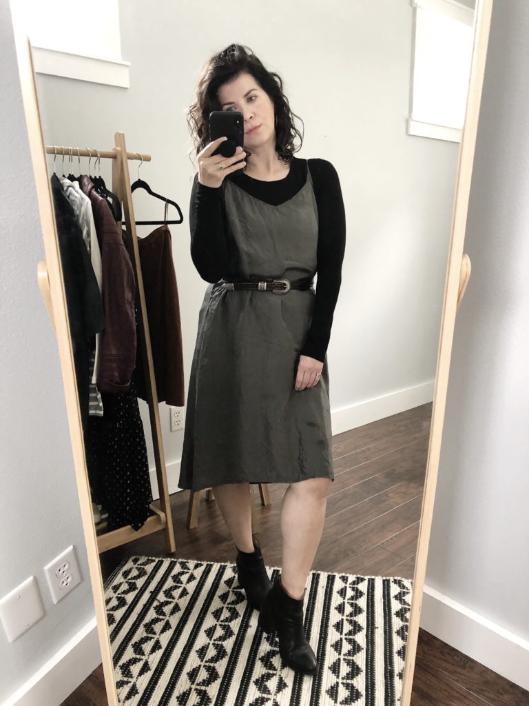 My interpretation of the first Pinterest inspired outfit. A woman takes a mirror selfie wearing a grey slip dress over a black long sleeve top with black boots and a black belt.