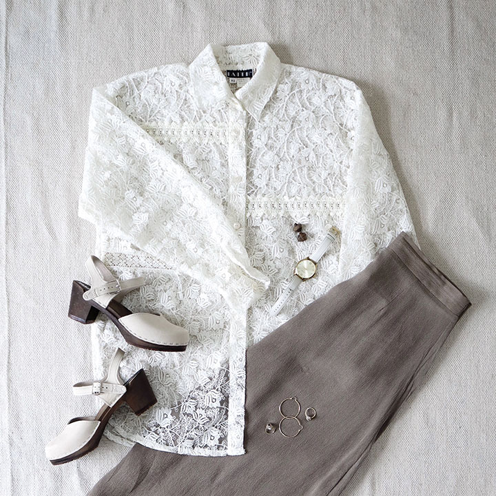 A flat lay of a white lace blouse with a tan skirt and the cream colored clog mule sandals in my shoe capsule.