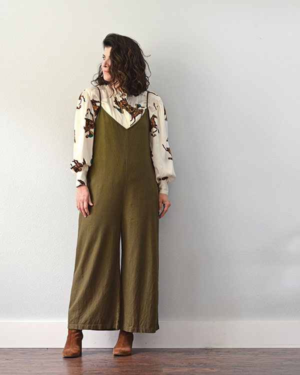 I am wearing my fist wardrobe staple...the olive green jumpsuit with a cream colored silk blouse underneath. The blouse has an equestrian print and I am wearing it with brown boots.
