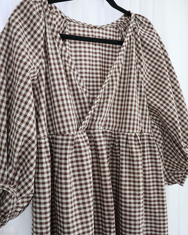 A partial image of a brown and white gingham summer dress that I made for my capsule wardrobe.