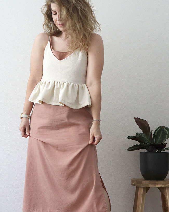 Mini capsule outfit 5 - a closeup of a pink slip dress under a white tank top cami with a ruffle hem.