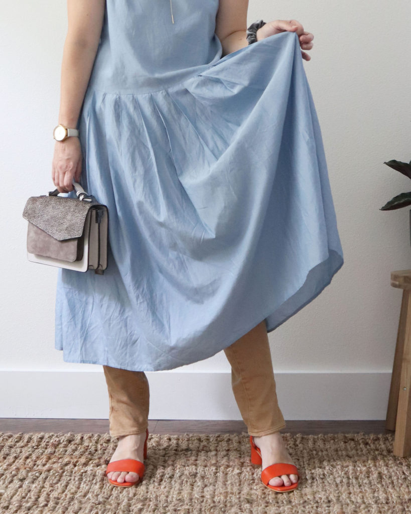 My fourth dress over pants look is a sky blue dress over tan pants with orange sandals and a grey satchel. This a partial photo of the outfit from the waist down.