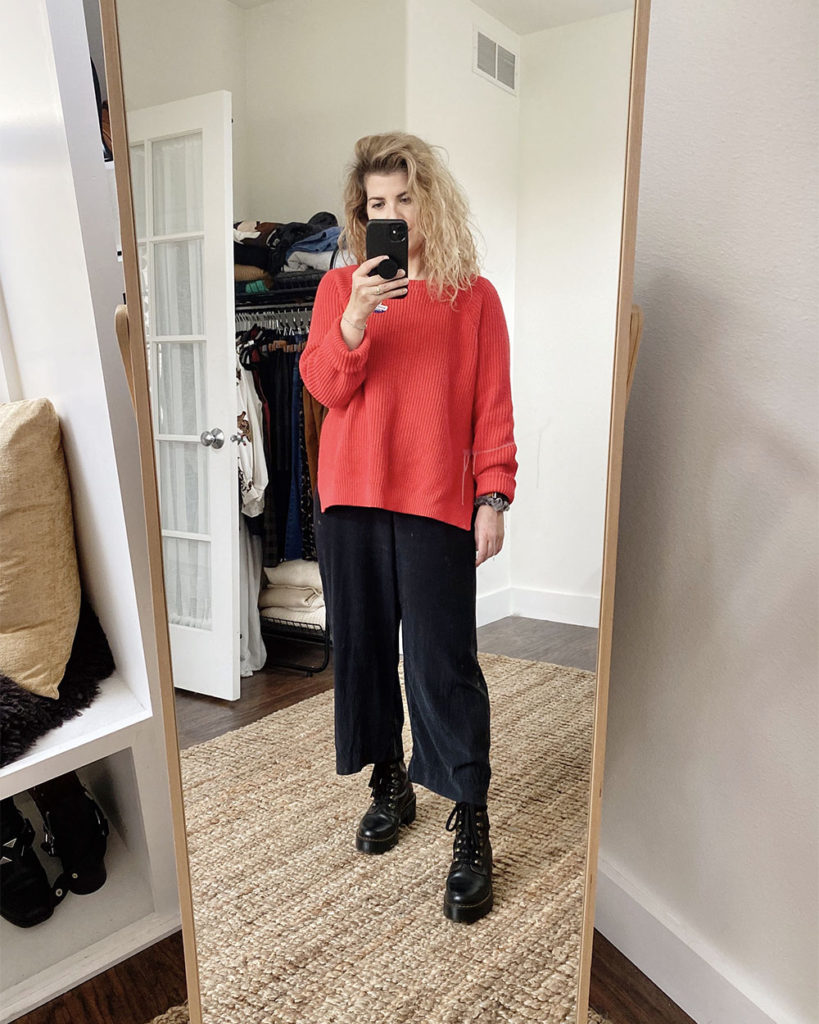 Sweater Outfit 4 - a mirror selfie of a white woman with wavy blonde hair wearing a red crew neck long sweater over a black jumpsuit with black combat boots. The next 4 photos are closeups or different angles.