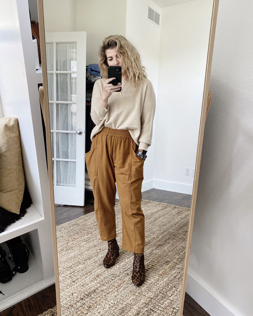 Sweater Outfit 5 - a mirror selfie of a white woman with wavy blonde hair wearing an oatmeal crew neck sweater a pair of caramel colored pants and leopard print boots. The next 4 photos are closeups or different angles.