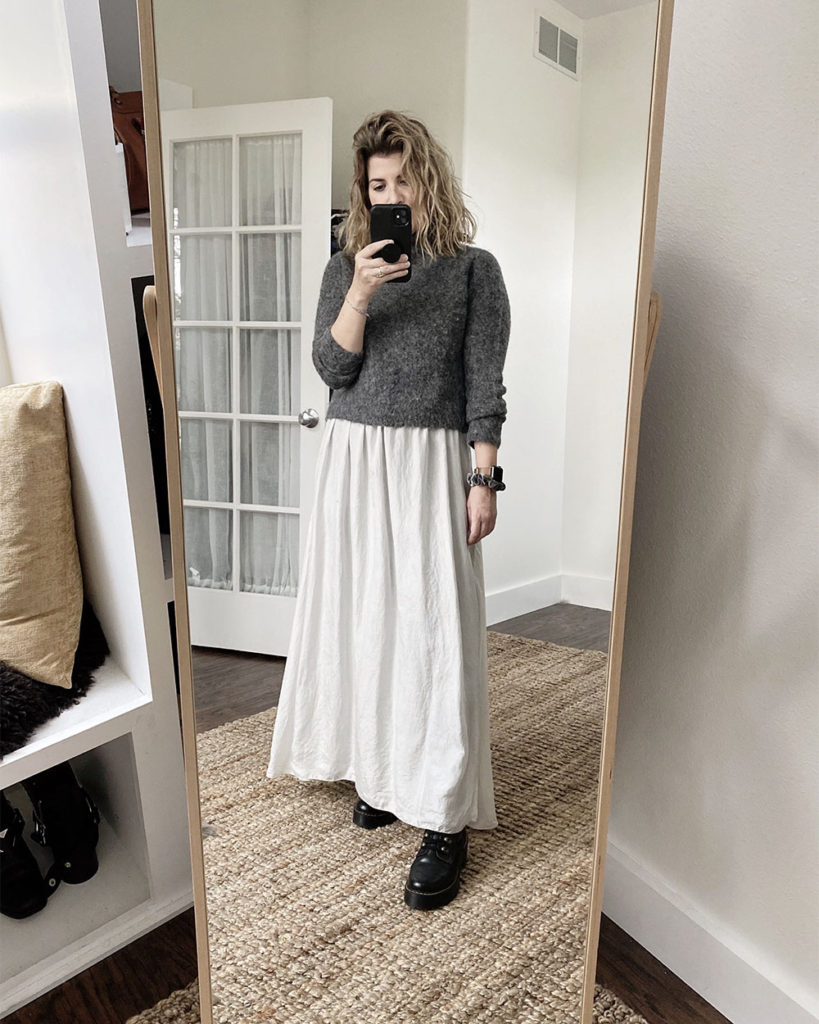 Sweater Outfit 6 - a mirror selfie of a white woman with wavy blonde hair wearing a dark grey mockneck sweater over a light grey dress with black combat boots. The next 4 photos are closeups or different angles.