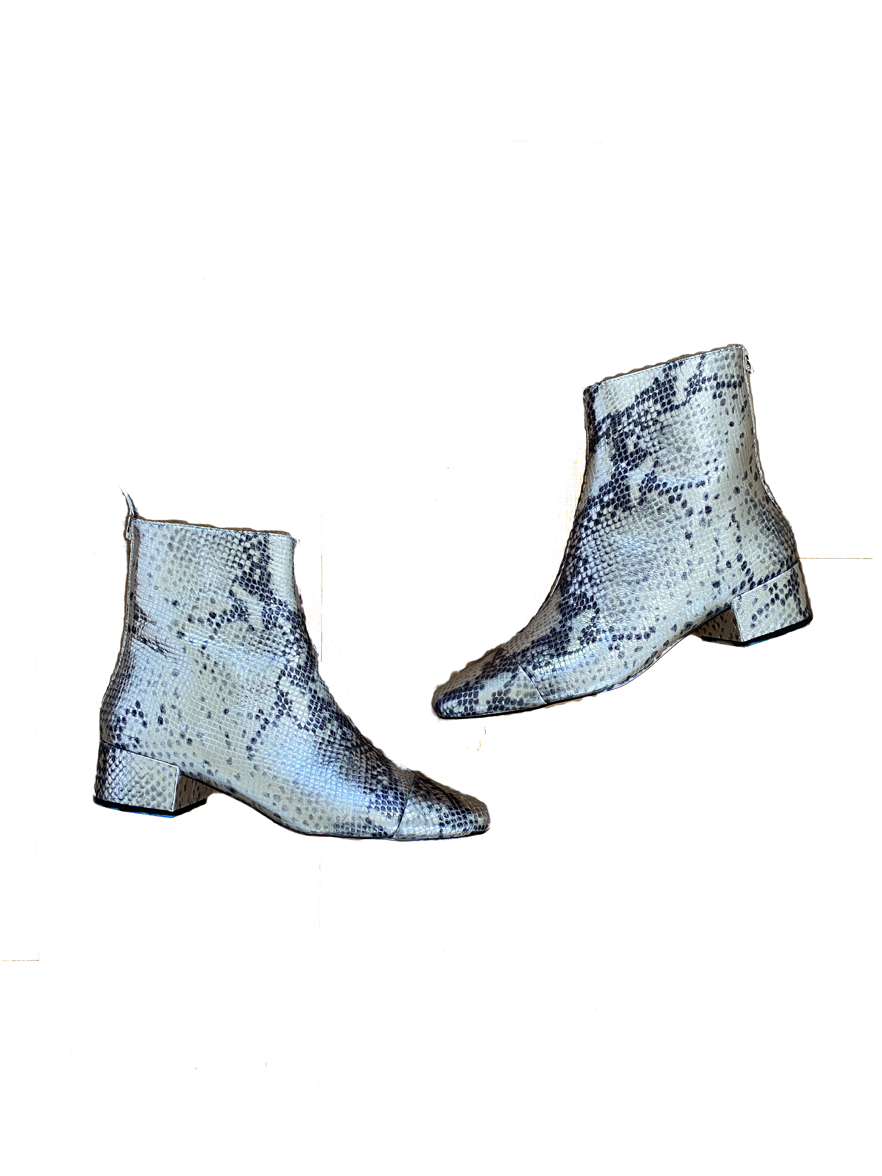 A pair of silver snakeskin boots with a 1 inch heel and a zipper up the back that I've included in my fall shoe capsule are silhouetted against a white background with text alongside them.