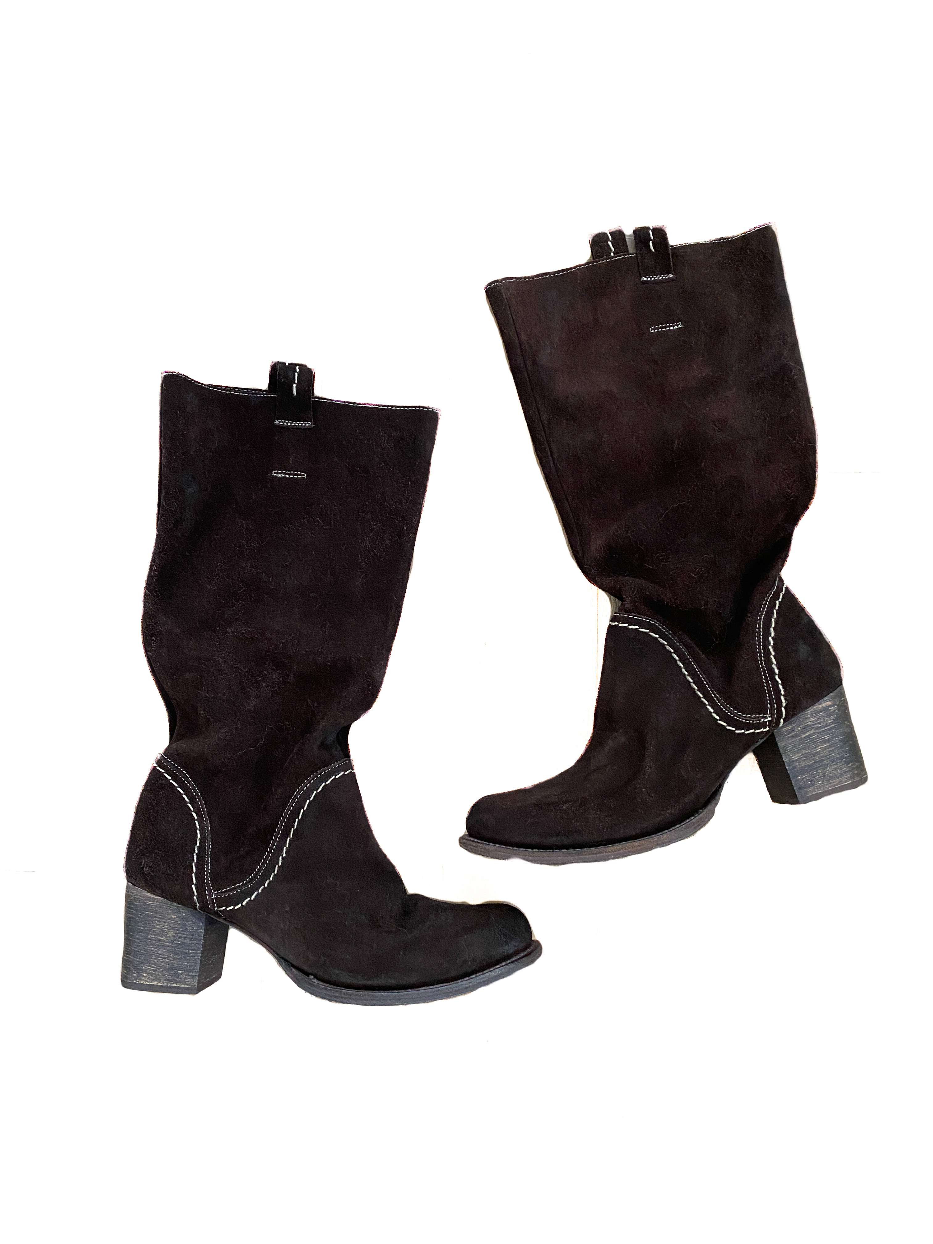 A pair of slouchy brown suede boots with white stitching and about a 2 inch heel are silhouetted against a white background with text alongside them.