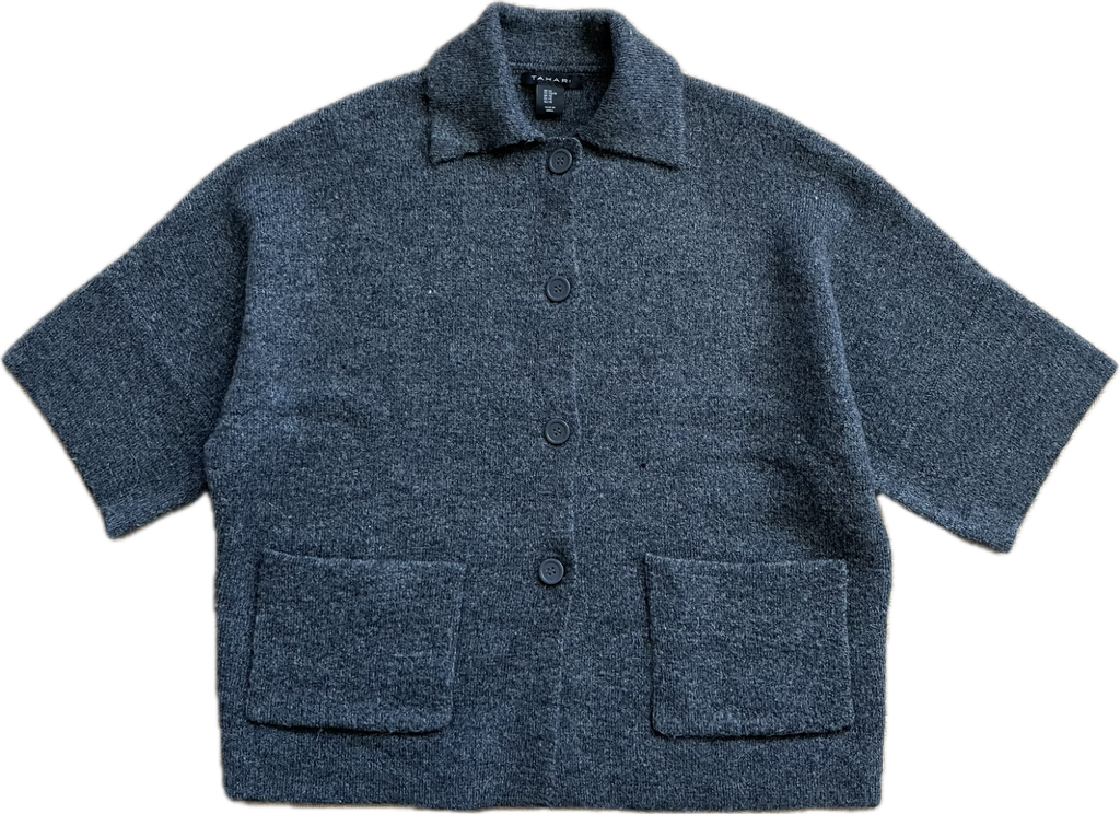A charcoal grey cardigan before the upcycle, laid flat with a white background. It has 3/4 length sleeves, a collar, 4 buttons up to the neck and 2 patch pockets at hip level.